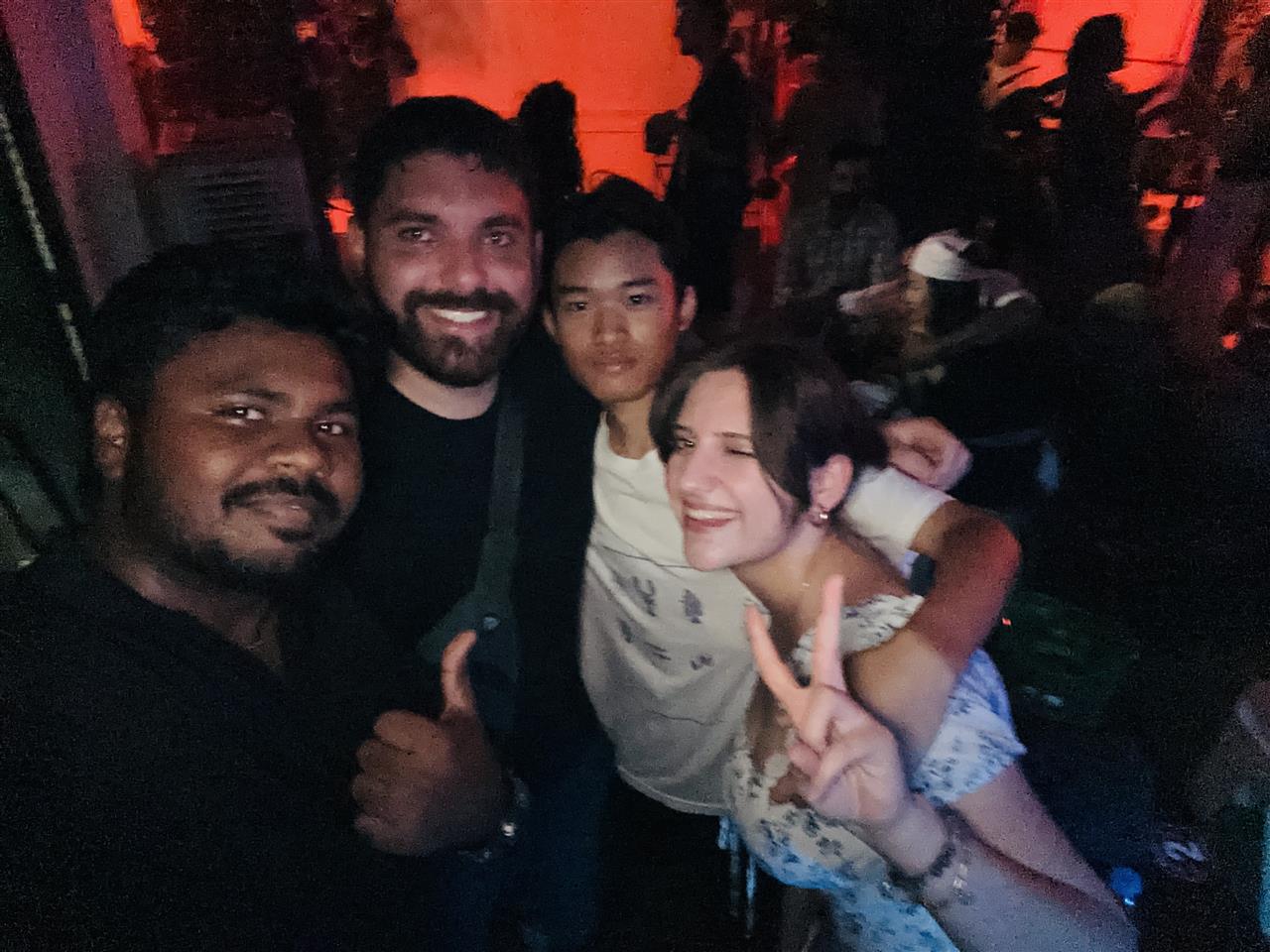 Four people posing for a selfie at an evening venue