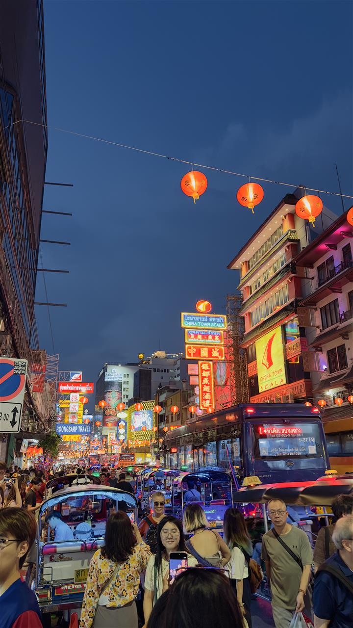 Yaowarat (Chinatown) street in Bangkok at night with neon signs, lanterns and tuk-tuks